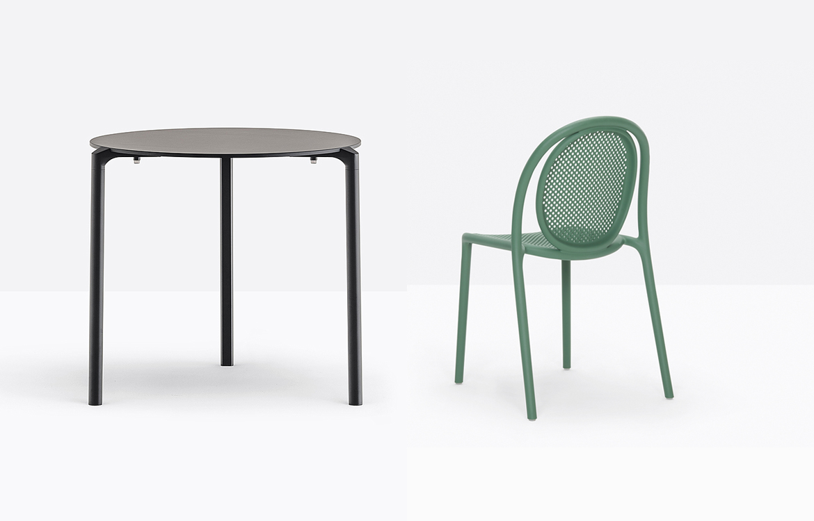 Black round cafe table with a green plastic cafe chair