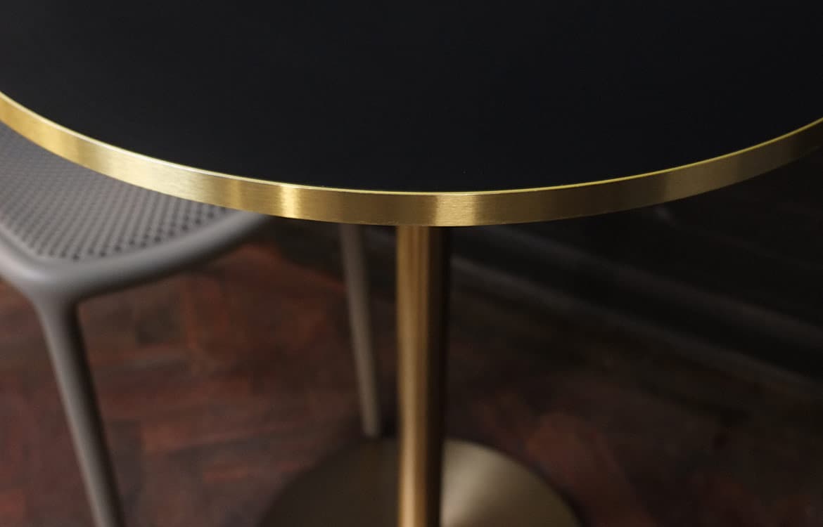 Brass cafe table black top closeup