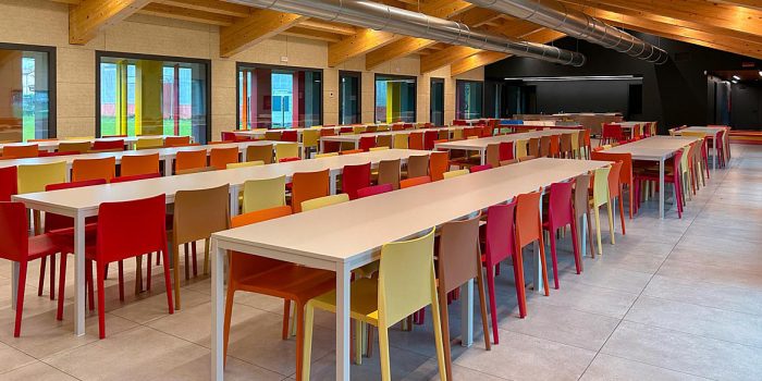 Colourful cafe chairs with long canteen table