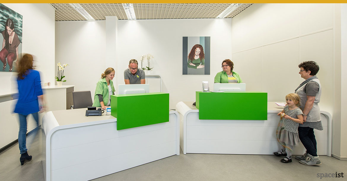 Hi-line white clinic reception desk with a green screen