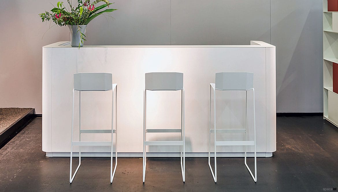 White reception desk with stools