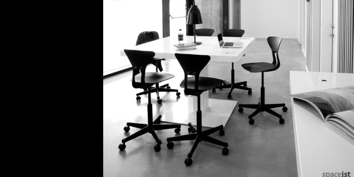Milk standing desk with high black stools